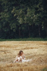 Mère allaitant son bébé en plein air, moment paisible