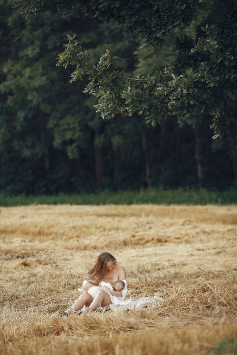 Mère allaitant son bébé en plein air, moment paisible