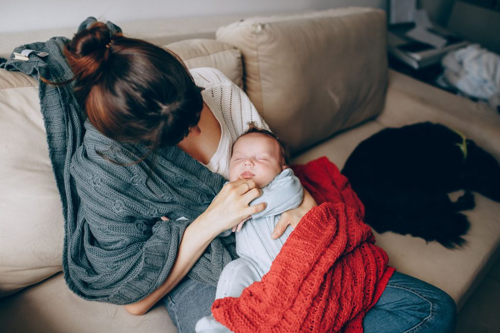 Jeune maman tenant son nouveau-né endormi contre elle