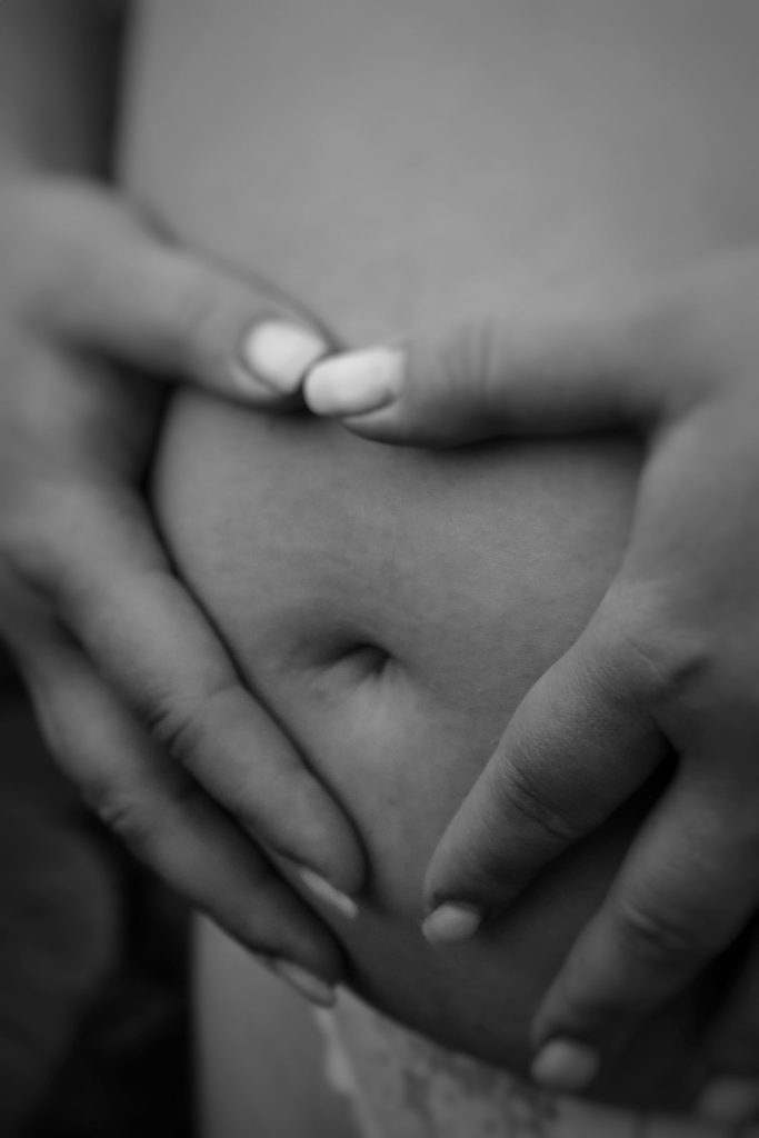 Mains formant un cœur sur un ventre de femme enceinte